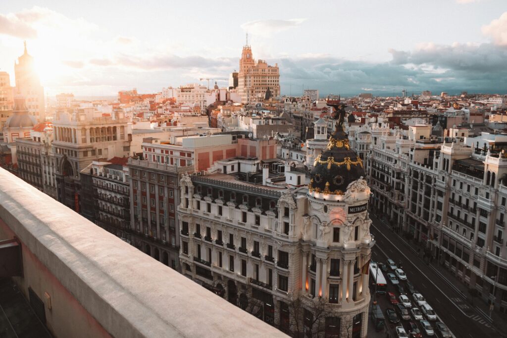 Vista aérea de Madrid con la Gran Vía en primer plano, tejados y skyline; parada recomendada en un itinerario de 1 día.